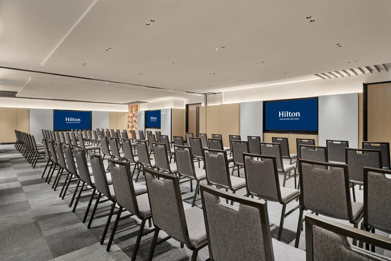 Hilton Singapore Orchard Level 5 Tembusu in theatre setup with modern hotel meeting room seating and integrated presentation screens
