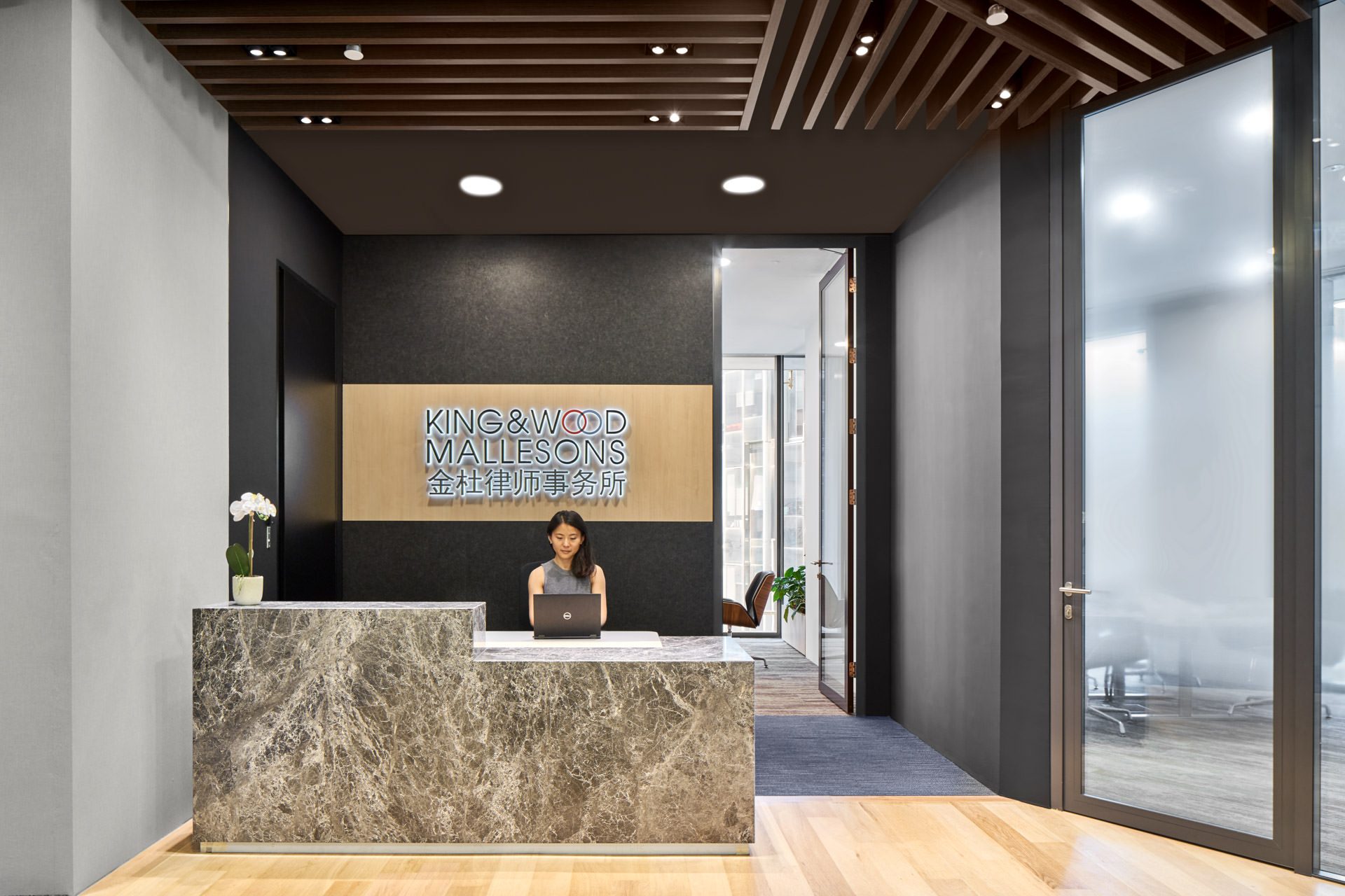 Reception desk with branded signage and glass-walled meeting rooms