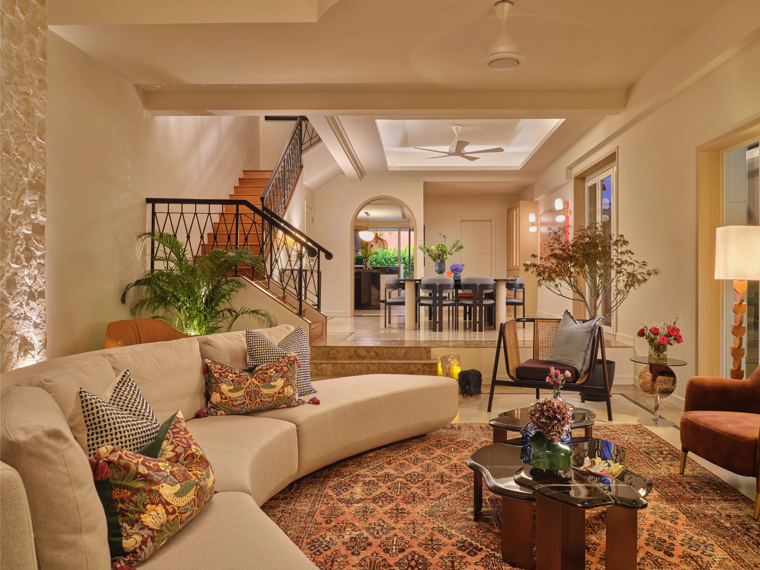 Living room with curved sofa, arched doorways and warm pendant lighting