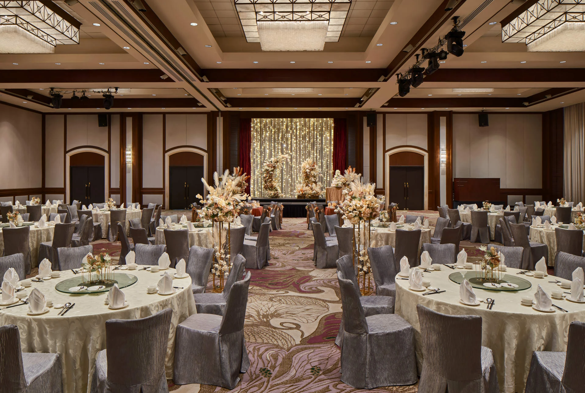 Paradox Singapore bohemian wedding setup with pampas grass, cream blooms, and fairy-light stage