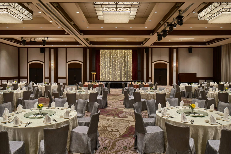 Paradox Singapore dinner and dance banquet with silver chairs, floral centrepieces, and fairy-light stage