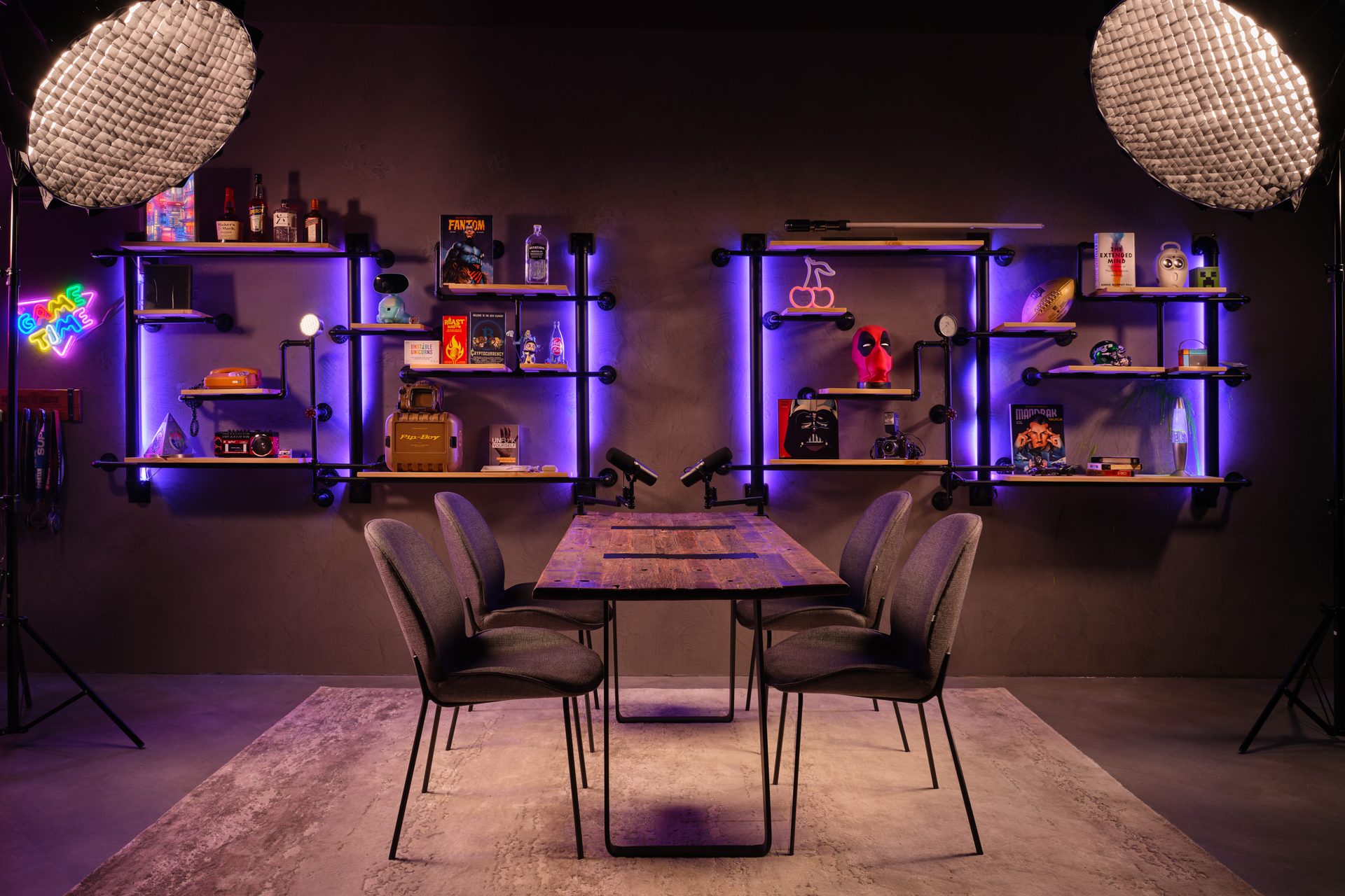 Industrial gaming podcast studio with purple LED pipe shelving and pop culture memorabilia