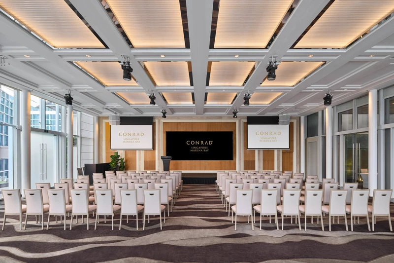 Conrad Singapore Marina Bay Pavilion in theatre setup with glass walls, garden views and bright hotel event seating