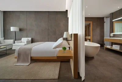 The Sanya EDITION king room with oak bed, freestanding egg tub and sheer divider