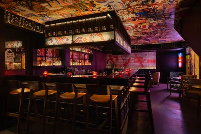 Ground floor bar with patterned seating, neon signage and Japanese pop art walls