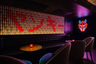 Downstairs lounge seating with pink neon sign and layered wall graphics