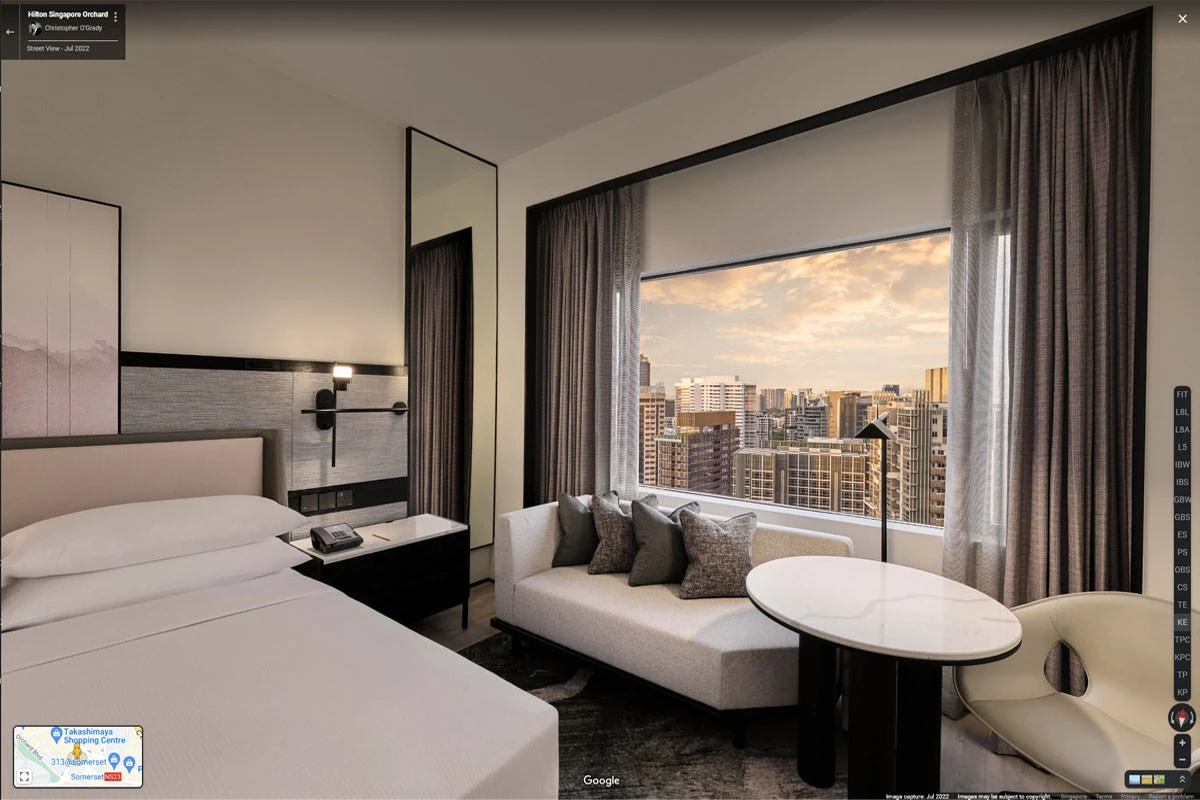 Guest room with king bed, sofa, and sunset city skyline view at Hilton Singapore Orchard hotel virtual tour